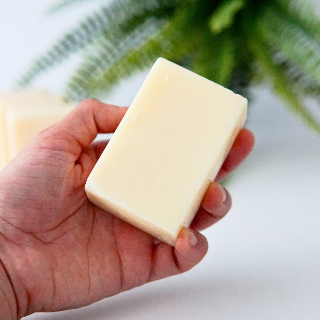 Hand holding a natural tallow soap bar during a skincare routine.