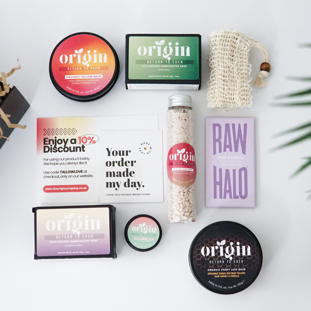 Origin Women’s Gift Box items displayed flat on a wooden table — organic skincare balms, soaps, and bath salts.