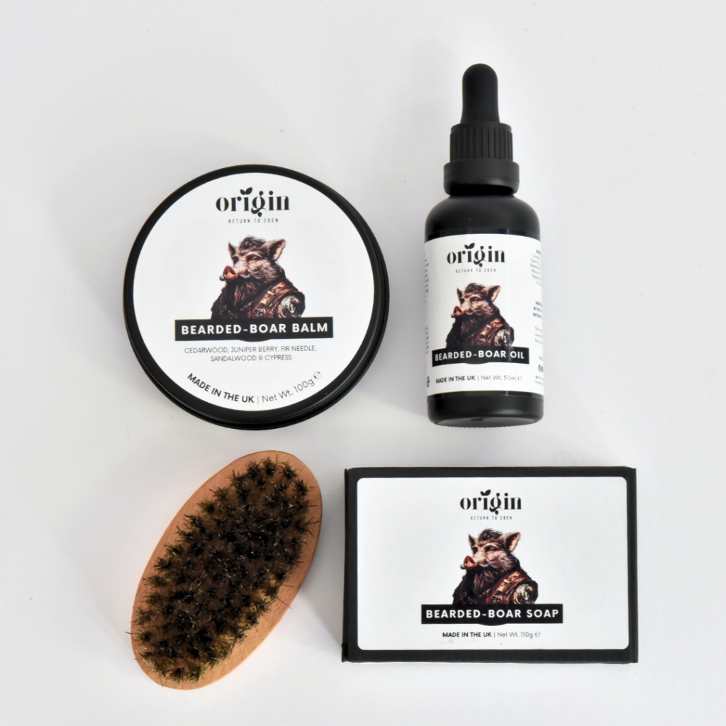Flat lay of the Bearded Boar Tallow Gift Set with balm, beard oil, tallow soap, and boar bristle brush arranged on a table